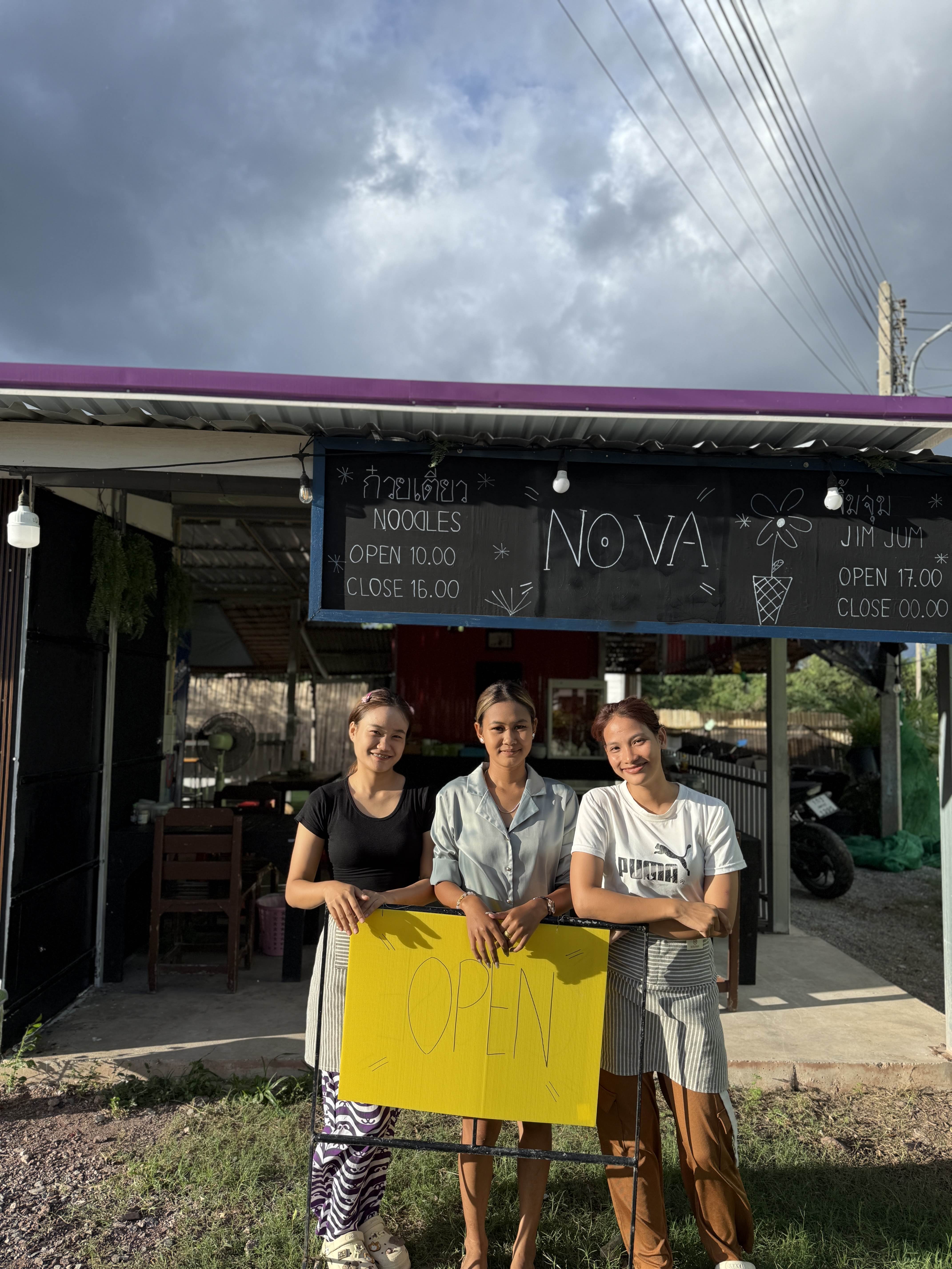 Nova Bar & Restaurant team members welcoming guests with OPEN sign